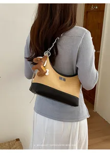 Detail shot of retro woven shoulder bag with chain strap and elegant turn-lock closure.