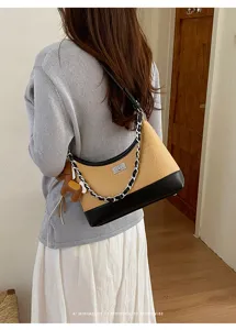Retro straw shoulder bag for women, chic leather contrast design with chain strap and lock.