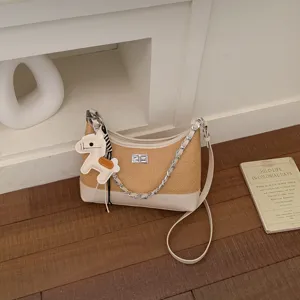 Detailed view of chic retro straw woven shoulder bag with chain strap and cute horse charm.