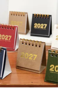 Nahaufnahme Detailansicht der bunten 2027 Mini-Tischkalender auf einem schönen Holztisch.