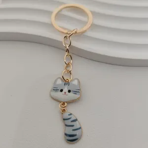 Detailed view of a cute tabby cat keychain featuring a gold metal ring and enamel pendant.