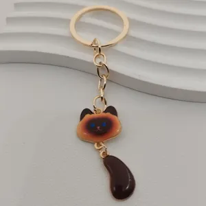Close-up detail of the cute cat keychain featuring golden metal finish and charming brown tail.