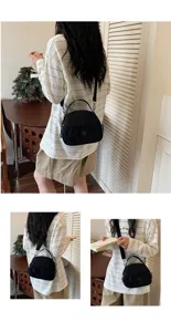 Detail shot showing the black nylon shell crossbody bag worn by a model indoors, stylish.