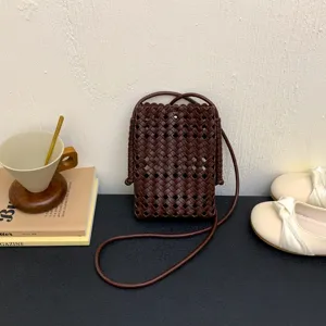 Dark brown woven leather mini phone crossbody bag with stylish thin shoulder strap for women.