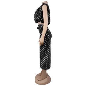 Black and white polka dot two piece set featuring a sleeveless crop top and high waist midi skirt.