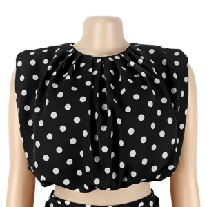 Close-up view of the black and white polka dot sleeveless crop top detail and fabric.