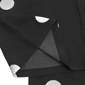 Close-up detail of black fabric with white polka dots and neat hem stitching for women.