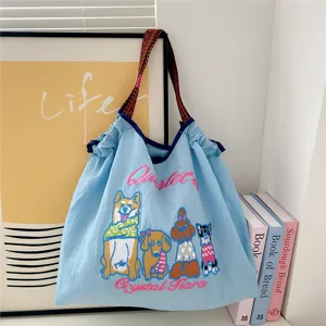 Detailed close-up view of the light blue canvas tote bag featuring cute cartoon dog embroidery.