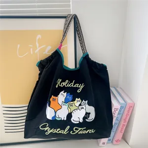 Detailed view of the cute cat embroidered canvas tote bag, featuring casual shoulder styling.