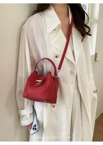 Red bucket bag detailed view showcasing premium leather texture, metal lock, and chic handle.