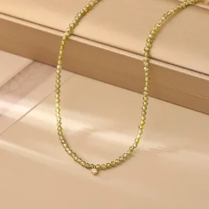Delicata collana di perle verde oliva sfaccettato con dettaglio di ciondolo in zircone.
