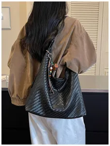 Zwarte geweven schoudertas detail, elegante slouchy shopper tas design met mooie bedels.