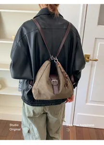 Nahaufnahme eines retro Wildleder-Rucksacks mit Metallschnalle in einem stilvollen Raum.