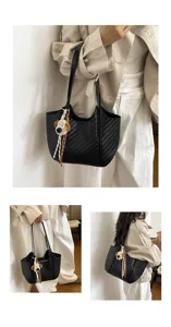 Detailansicht der stilvollen schwarzen gewebten Tasche mit niedlichem Plüschwelpenanhänger.
