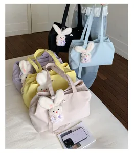 Detail view of Korean style large capacity tote bag with cute plush bunny charm for women.