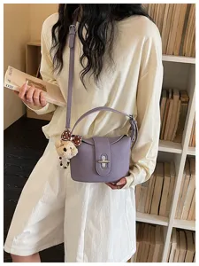 Purple litchi texture bucket bag with top handle and cute bear charm for women daily commute.
