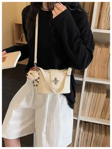 Detail shot of chic lychee pattern crossbody bucket bag featuring stylish metal lock.