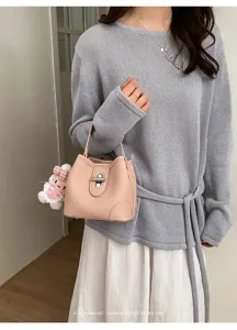 Stylish women's bucket handbag crafted from textured leather with a chic metal lock design.