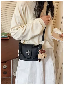 Black PU leather crossbody bag with metal lock and cute bear charm pendant detail.