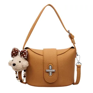 Chic bucket bag for women, stylish leather crossbody purse with cute plush dog pendant.