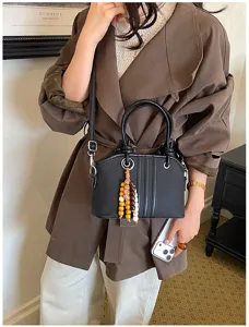 Stylish black top-handle crossbody bag for women, premium commuter handbag with beaded charm.