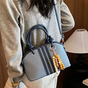 Women's commuter canvas handbag stylish crossbody bag with wooden bead pendant and top handles.