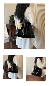 Detailed scene view of the black glossy tote bag with cute bear pendant in daily lifestyle.