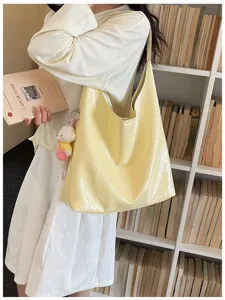 Yellow glossy soft leather tote bag detail view, casual commuting minimalist single shoulder bag.