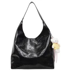 Black crinkled patent leather hobo bag with cute plush bear pendant, large capacity.