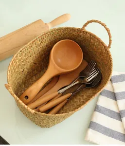 Gros plan sur le panier de rangement en paille tressée naturelle aux finitions soignées.