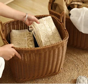 Imitation rattan laundry basket with woven handles and beige crochet fabric inside.