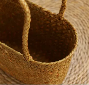 Gros plan détaillé d'un panier en paille tissée à la main, texture naturelle, double poignée.