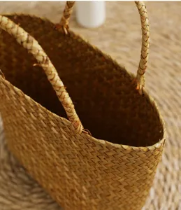 Handcrafted straw woven basket bag with double handles, natural wicker material detail showcase.