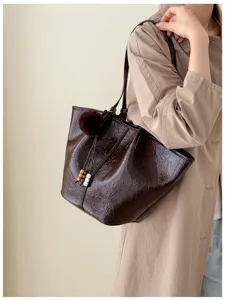 Dark brown crinkled leather tote bag for women, stylish commuter shoulder bag with charms.