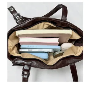 Sac cabas en cuir marron vintage à grande capacité, détail de vue intérieure de sac bandoulière.