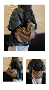 Detail view of stylish brown oil wax leather shoulder bag, large capacity casual daily use.