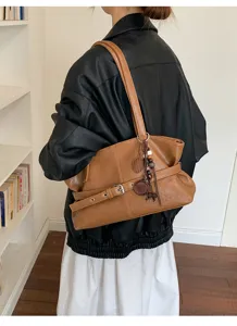 Vue détaillée du sac porté épaule marron rétro avec boucle élégante et joli pendentif.