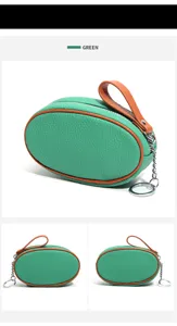 Green genuine leather mini coin purse with brown trim, zipper and keychain ring detail.