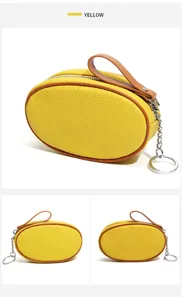 Detail view of yellow oval genuine leather coin purse with contrast brown trim and key ring.