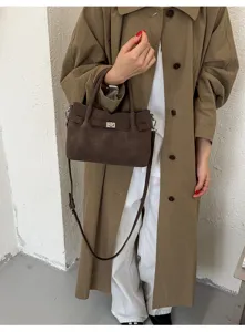 Detailaufnahme der Wildleder Umhängetasche, braune Vintage Handtasche mit Metallverschluss.
