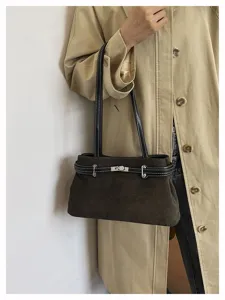 Detailaufnahme der braunen Wildleder-Umhängetasche mit Metallverschluss und doppelten Riemen.
