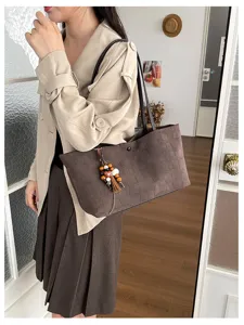 Detailansicht einer Vintage Krokodilmuster Tasche mit Perlen Quasten Anhänger.