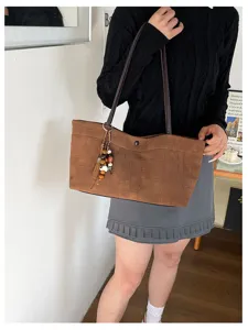 Elegante Damen Umhängetasche mit Krokomuster, braune Shopper Tasche mit stilvollen Anhängern.