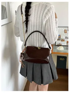 Chic brown leather shoulder bag for women, stylish pillow design with braided handle and chain.