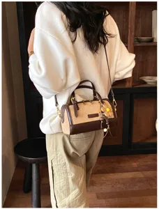Detailed lifestyle view of retro women pillow shoulder crossbody bag with cute flower charm.