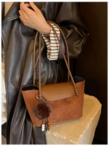 Braune Wildleder Umhängetasche Detail, Vintage Shopper mit Klappe und Bommel Anhänger.