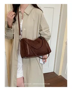 Gedetailleerd shot van de retro bruine suède schoudertas in een minimale dagelijkse outfit.