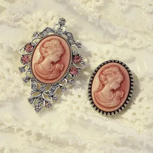 Vintage cameo portrait brooch detail shot, elegant carved women profile with rhinestones.