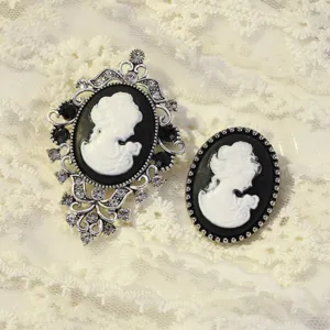 Detailed close-up of retro black and white cameo brooches with ornate silver rhinestone setting.