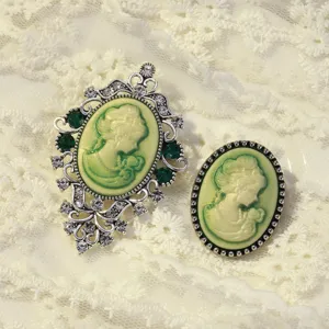 Vintage cameo brooch set with green stones and rhinestones, elegant Victorian palace style accessory.